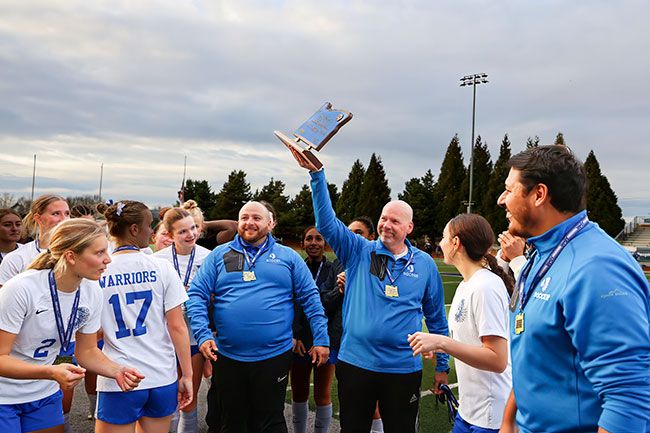 Rachel Thompson/News-Register file photo##Andy Dyer raises the 3A/2A/1A Girls&rsquo; State Championship trophy for the Amity faithful to see after the Warriors title-game victory over Valley Catholic on Nov. 15, 2025 at Falcon Stadium in Hillsboro.