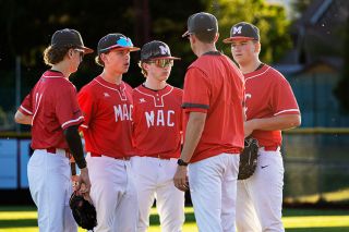 Nathan Ecker/News-Register##From left to right: Wyatt Wallace, Caleb Gray, Liam Batey and Hayes Wrigley heed the wisdom of Head Coach Todd Peterson during a pitching change in the Grizzlies&rsquo; summer ball contest versus the Baseballism Wet Sox on Wednesday, July 20. Every out during the club season for these players comes with a lesson learned. While players like Gray and Wrigley look to lead, other youngsters like Wallace and Batey seek to improve with each game. Batey impressed against the Wet Sox with an over the back nab of a pop fly while at second base.