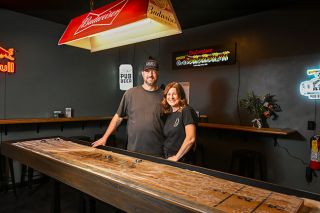 Rusty Rae/News-Register##Dustin and Christine Brungardt, standing behind the shuffleboard table she built from reclaimed flooring from a vintage Portland home, opened Dusty&rsquo;s Pub in the former Roadhouse space in Lafayette. They said they want the bar and restaurant to be a community gathering space.