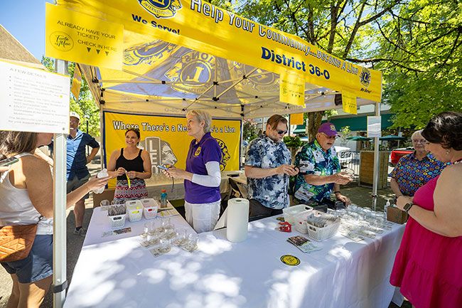Photos by Rachel Thompson/News-Register##McMinnville Lions Club members Jamie Libonati, left, and her mother, Kim Libonati, along with Chris Sauer and his father, Brian Sauer, check in Saturday&rsquo;s Taste of Mac participants.