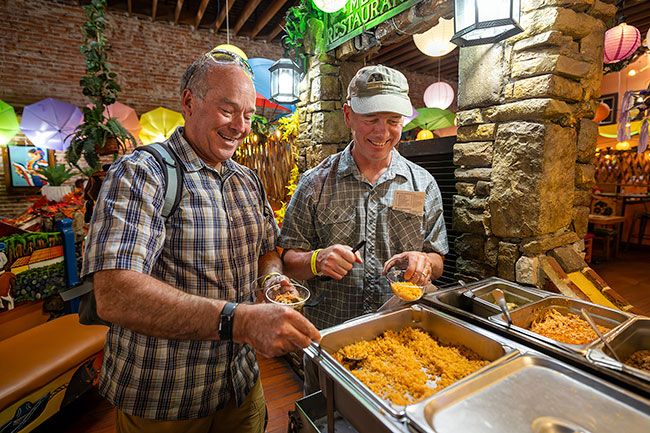 Photos by Rachel Thompson/News-Register##Brent Husband and Bob Collins, both of Durham, help themselves to a mini buffet of Mexican fare at Los Molcajetes. The friends made a return trip with their wives after enjoying the event last year.