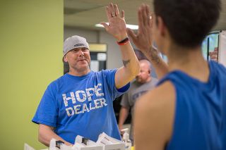 Rachel Thompson/News-Register##Richie Inman, left, high-5&rsquo;s Hope on the Hill food bank volunteer Omar Franco. Inman is a certified recovery mentor for Provoking Hope who serves as a live-in manager at a Hope House. He encourages residents to do community service at the food bank or other places.