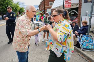 Rachel Thompson/News-Register##Parade announcer David Blanchard, left, holds the microphone for his daughter, Ohio resident Sarah Blanchard-Webster, as the Carlton Fun Days parade winds down on Saturday. Blanchard has been part of the festival since moving his family to Carlton in 1974.