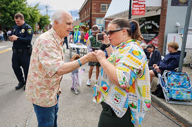 Rachel Thompson/News-Register##Parade announcer David Blanchard, left, holds the microphone for his daughter, Ohio resident Sarah Blanchard-Webster, as the Carlton Fun Days parade winds down on Saturday. Blanchard has been part of the festival since moving his family to Carlton in 1974.