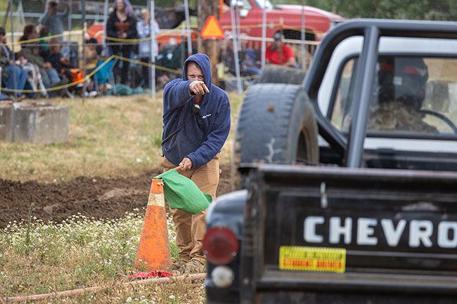 Nathan Ecker/News-Register##Jeffery Lockwood of Sheridan points to a driver on the starting line of the muddy drag strip to ensure the contestants are prepared to take off at the raising of the green flag. Most drivers sped off the start with ease, but a fair share stalled out in anticipation. Only one vehicle on the entire day needed the assistance of the tow truck due to mechanical issues.