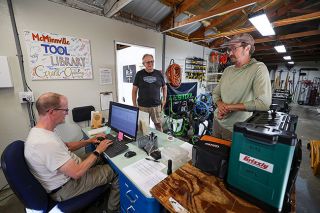 Rachel Thompson/News-Register##Phil London of McMinnville, right, chats with McMinnville Tool Library volunteers Larry Gilbertson, left, and Wes Taylor while checking out a planer, hand router and router bits. London borrowed the tools to make a cutting board from scrap butcher block.