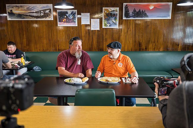 Rachel Thompson/News-Register##Coyote Joe&rsquo;s owner Chris Deprimo, left, talks with &ldquo;America&rsquo;s Best Restaurants Roadshow&rdquo; host Luis Rivera during filming June 30 in Willamina as Rivera samples the restaurant&rsquo;s chicken fried steak. The online series, which features locally owned restaurants across the country, visited Coyote Joe&rsquo;s after the restaurant was nominated by community members. The episode is expected to premiere this fall.