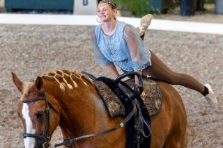 Photo courtesy of EVUSA##Sarah-Anne House twirls around the back of her steed during an equine vaulting training camp. In the sport, traditional saddles are replaced with a special surcingle with handles, which aid the vaulter in performing certain moves. For competitions, House often rides borrowed horses, creating a loving relationship with each one.