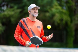 Rachel Thompson/News-Register##Wes Gabrielsen catches a pickleball in one hand while holding a paddle in the other during an impromptu practice session at the McMinnville Lower City Park courts. When not on the road, Gabrielsen frequents the courts to join games and say hello to friends. Now when attending, he sees much younger faces than before, which brings a smile to someone hoping to support a youth movement.