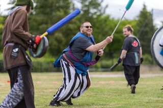 Rachel Thompson/News-Register##Adam Logan wields his pike as he looks for his next victim while Morgan Olin, left, casts spells and Cameron Ray, right, uses his assassin stealth to sneak through the battlefield during a weekly live action role-playing (LARP) game at Discovery Meadows Community Park.