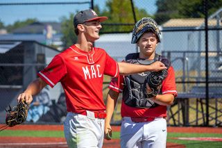 Nathan Ecker/News-Register##Taylor Carnahan cheerfully returns to the home dugout at Patton Middle School with a gloved fist bump offered from his catcher, Hays Wrigley, after completing four, one-hit innings against Southridge on Sunday, July 12. Carnahan had surrendered five hits and nine earned runs in as many previous innings, but finally found his confidence post-injury with a dominant performance to close the summer.