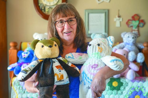 Rachel Thompson/News-Register##Jeanne Heuberger Weirich of McMinnville cradles memory bears she creates from the clothing and cherished fabrics of loved ones who have died. Her father, Louis Heuberger, helped stuff the handmade bears after being diagnosed with Alzheimer&rsquo;s disease.