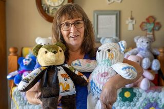 Rachel Thompson/News-Register##Jeanne Heuberger Weirich of McMinnville cradles memory bears she creates from the clothing and cherished fabrics of loved ones who have died. Her father, Louis Heuberger, helped stuff the handmade bears after being diagnosed with Alzheimer&rsquo;s disease.