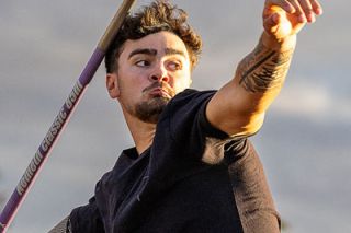 Nathan Ecker/News-Register##Kiyan Vrell captures the afternoon rays of a cloudy day over Amity while hurling his javelin just a few feet shy of his personal record at Amity Thursday Throws No. 3 on July 16. Vrell reached 191-3 with his toss in what is an area of practice for most of the attending throwers. His PR is 195-5 1/2, set at the 2026 George Fox University NCAA Final Qualifier in May.