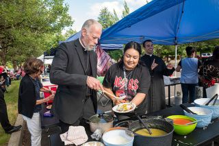 Rusty Rae/News-Register##Archbishop Alexander Sample of the Portland Diocese ladles some sauce onto an enchilada with the assistance of Veronica Curiel, one of the many &ldquo;chefs&rdquo; who provided a variety of meals during Saturday&rsquo;s 150-year celebration of St. James Church. In the background is Justin Echevarria, parochial vicar at St. James.