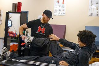Nathan Ecker/News-Register##Grizzlies Athletic Trainer Logan Hurley checks senior Nesta Nelson for potential injury in the trainer&rsquo;s room at McMinnville High School. Nelson first worked with Hurley in the fall during football season, but Hurley&rsquo;s presence and time at Mac High have made more athletes comfortable with seeking out his professional opinion any time of year.&nbsp;