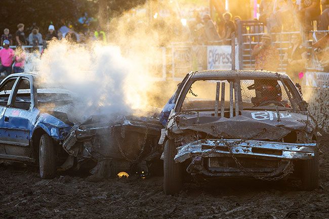 Rachel Thompson/News-Register##Steam rises from battered cars as grandfather Loren Sullenger of Aurora, left, and grandson Nathan Conant of Newberg face off as the final two drivers remaining in the 20-car hornet class of the demolition derby at the Yamhill County Fair on Saturday, August 1.