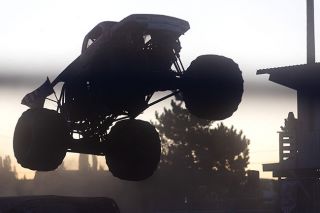 Nathan Ecker/News-Register## Cloaked by twilight, Carolina Crusher driven by Paul Craighead of Roanoke, Virginia, makes its final leap over semiflattened vehicles to claim victory over the day&rsquo;s final monster truck freestyle event.