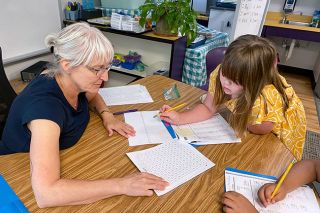 Starla Pointer/News-Register##Summer school teacher Barb Roush helps third-grader Juniper Jerman with math problems during a class last week at Grandhaven Elementary School. Roush retired from the school in June, but returned to help with the three-week summer program. Students in grades 1 through 8 participated throughout the McMinnville School District.