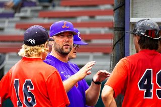Nathan Ecker/News-Register##Linfield Baseball Head Coach Jordan Harlow speaks with players on the Red team during scrimmages at the Linfield Baseball Camp on Saturday, Aug. 15. Around 30 campers were split into two teams on day two of the weekend camp, giving players an opportunity to show their skills and receive feedback from college coaches.