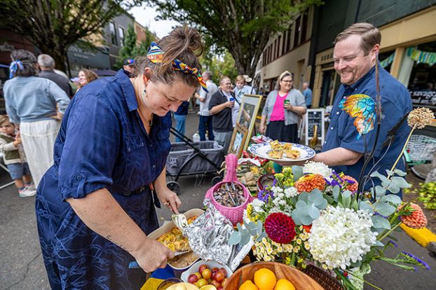 Rachel Thompson/News-Register##Fiona Mancill, whose elaborate table decorations caught the eyes of many diners, serves a breakfast casserole to her husband, Duane. Many tables were laden with casseroles, egg dishes, sausages and other traditional breakfast foods; others had salads, salmon, grits and Bunny Belly Bagels from down the street.