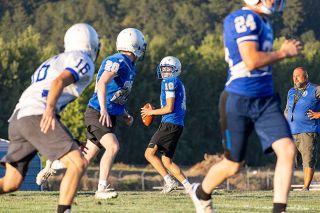 Nathan Ecker/News-Register##Amity senior Simon Dick drops back, looking for an open receiver during the Warriors&rsquo; annual Blue and White Night scrimmage on Friday, Aug. 21. Dick is likely to lead the Amity offense this fall, giving his team a calm presence in the huddle as they look to change their attitudes from last season.