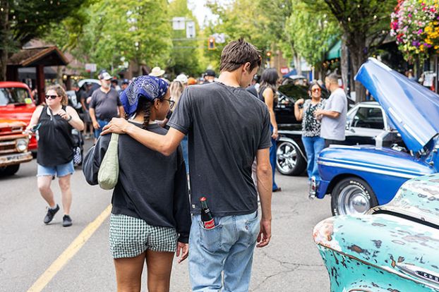 Rachel Thompson/The News-Register##A couple strolls past the polished classics and patina-covered pickups lining Third Street.