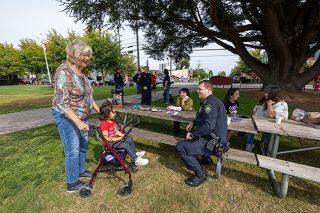Rachel Thompson/News-Register##Connie Burge and her 3-year-old great-granddaughter, Sophia Bowlin, visit with Carlton Police Officer Micah Steeves during Coffee with a Cop on Friday at Ladd Park.