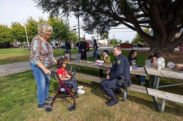 Rachel Thompson/News-Register##Connie Burge and her 3-year-old great-granddaughter, Sophia Bowlin, visit with Carlton Police Officer Micah Steeves during Coffee with a Cop on Friday at Ladd Park.