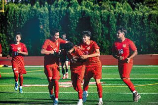 Rusty Rae/News-Register##Junior Jonathan Espinoza Flores and senior Edwin Cuevas George mob sophomore Eduardo Vazquez after having scored the Grizzlies first goal of the season, a 20-yard looper from the right of the net during Mac&rsquo;s jamboree contests at Wortman Stadium on Thursday, Aug. 27.