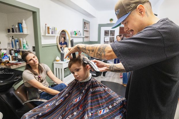 Rachel Thompson/News-Register##Marni Cochran watches as barber Gerardo Ramirez gives a free haircut to her 4-year-old, Maverick, who will be starting 
pre-kindergarten Monday at Newby Elementary School.