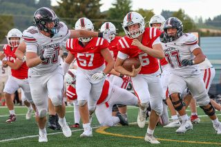 Nathan Ecker/News-Register##Junior quarterback Gabriel Mahn escapes the pocket as defensive lineman from Sandy bear down from the sides. Mahn appears to have won the Grizzlies starting QB position and made several precision passes at the jamboree, including a touchdown caught on the helmet by senior Rhyder Darnell.