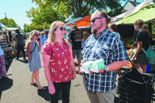 Rusty Rae/News-Register##McMinnville City Manager Adam Garvin chats with resident Marie Gwilliam at last week&rsquo;s Farmers Market. Garvin has been on the job for just over a year, following eight years as a city councilor.