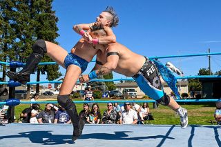 Rusty Rae/News-Register##AJ Koston, left, gets wrestler Marcus Eriks into a cutter move before throwing him down on the mat. Koston and Eriks pulled each other&rsquo;s spiked hair and traded slaps before the crowd in Lafayette&rsquo;s Commons Park.