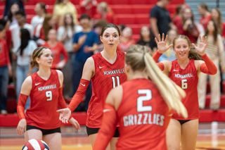 Rachel Thompson/News-Register##Senior middle blocker Emily Hutchison and teammates emphatically approach senior Molly Tharp for a point won.