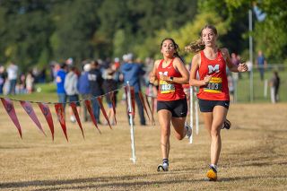 Nathan Ecker/News-Register##Senior Gianella Contreras-Rodriguez and sophomore Bella Cox speed down the final stretch of the girls&rsquo; varsity 5,000-meter race. The duo placed two seconds apart, with Cox in 17th and Contreras-Rodriguez in 18th, to mark the Grizzlies&rsquo; fifth and sixth finishers. Cox, a Marshfield High School transfer who was the Pirates quickest finisher at the 2025 4A Sky-Em League Championship, was running her first 5K as a Grizzly.