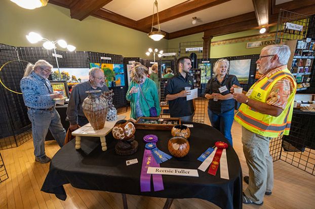 Rachel Thompson/News-Register##Visitors mingle among works by local artists during the Art Harvest Studio Tour opening reception Saturday at Rose of Third Street in downtown McMinnville. The exhibit offered a preview of work by artists participating in next month&rsquo;s 32nd annual tour. Dozens of artists will open their studios to the public for two weekends &mdash; Oct. 2-4 and 9-11.