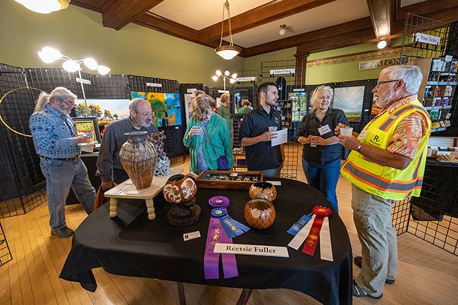 Rachel Thompson/News-Register##Visitors mingle among works by local artists during the Art Harvest Studio Tour opening reception Saturday at Rose of Third Street in downtown McMinnville. The exhibit offered a preview of work by artists participating in next month&rsquo;s 32nd annual tour. Dozens of artists will open their studios to the public for two weekends &mdash; Oct. 2-4 and 9-11.