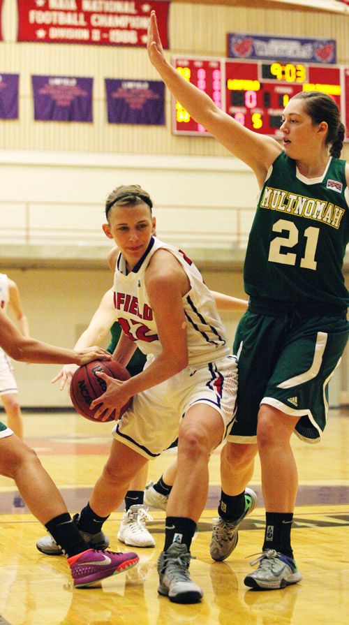 Rockne Roll/News-Register##Linfield senior Hannah Depew (32) drives past Multnomah junior Lacie Kemper (21) during the Wildcats  87-67 victory over the Lions Friday evening at Ted Wilson Gymnasium.