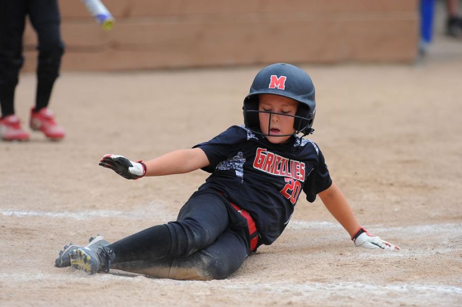 Rusty  Rae/News-Register##
McMinnville s Hallie Woods  slides  home with an insurance run during the game against the Canby Rebels.