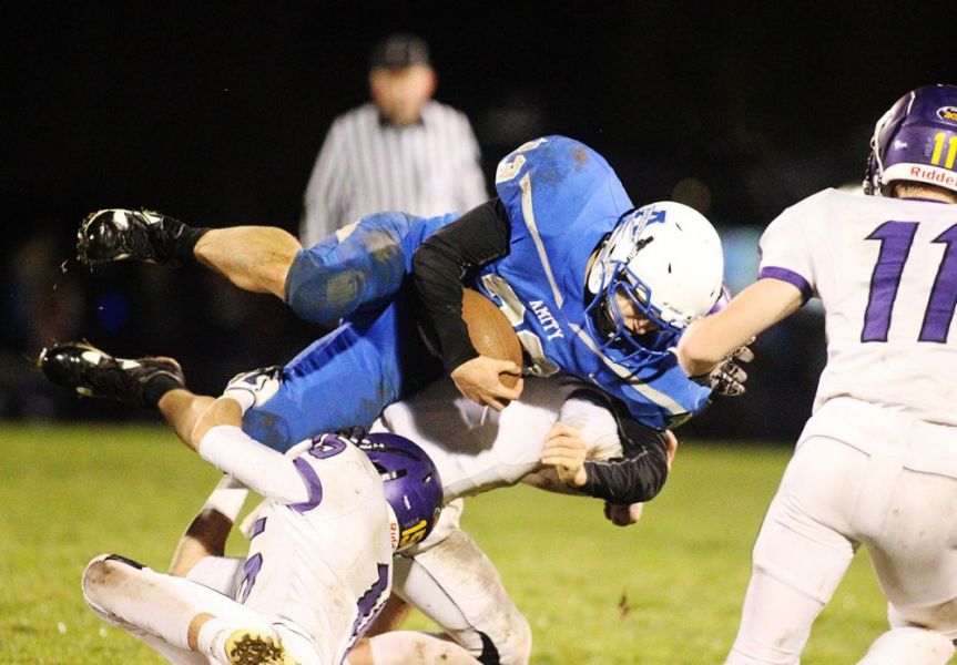 Rockne Roll/News-Register##
Amity running back Jonathan Mather is upended by a Harrisburg defender during Friday s 42-36 Eagle triumph in the first round of the state playoffs.