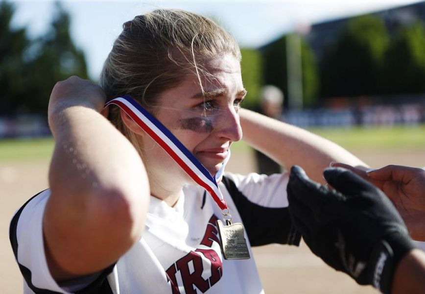 Rockne Roll/News-Register##
Dayton pitcher Ani Heidt puts on her winners  medal after the Pirates  victory over Rainier in the OSAA Class 3A Softball state championship game  Friday, June 1, at Oregon State University in Corvallis.