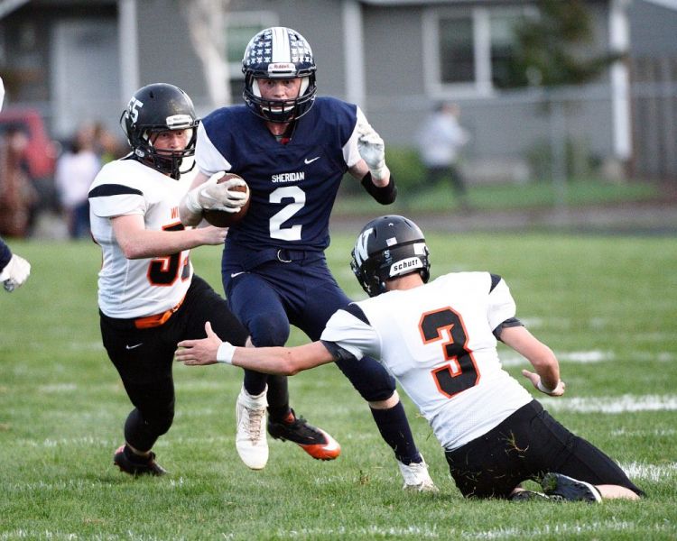 Marcus Larson/News-Register##
Sheridan s Elliott Henley (2) breaks a tackle during a rushing play in tonight s rivalry game against Willamina. Bulldogs Conrad Farmer (3) and Kyle Anderson (55) attempt to stop Henley.