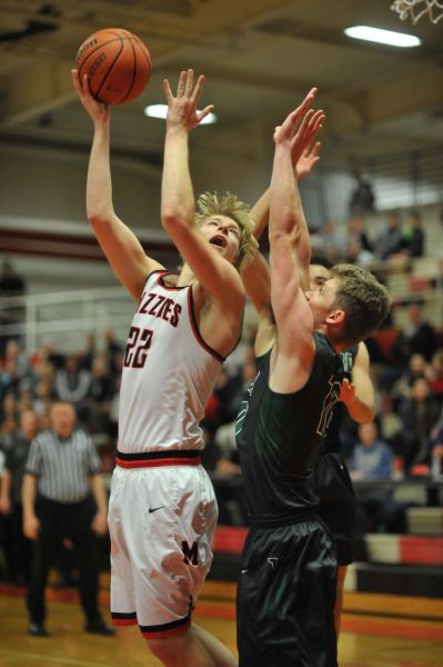 Susan Ragan for the News-Register##
The Grizzlies  Aaron Baune is guarded by two Tigard players, but scores over the top of them. He had 31 points to lead all scorers as Mac won 61-58.