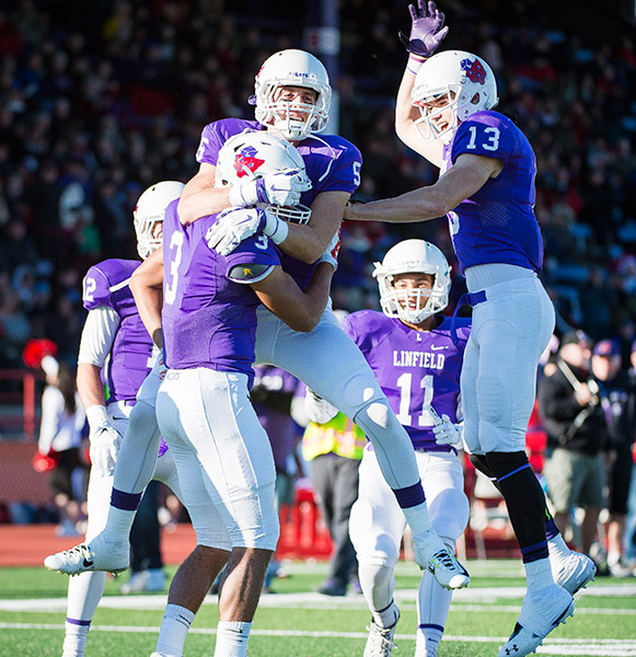 Marcus Larson/News-Register##Linfield s Eric Igbinoba is mobbed by his teammates after a long touchdown reception.