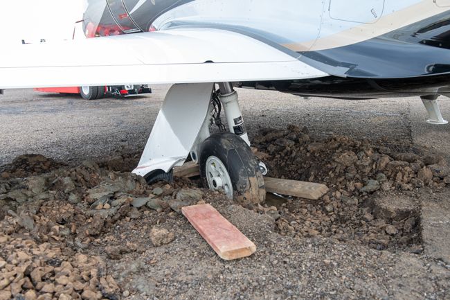 Rusty Rae / News-Register##The wheel of a busness  jet broke through old tarmac at the McMinnville Airport Friday.