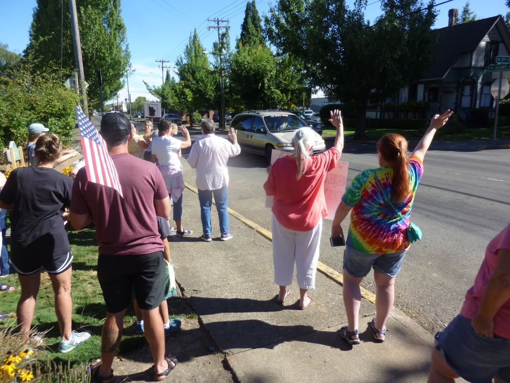 Starla Pointer / News-Register##Participants in an impromptu peace and diversity rally wave a passing traffic Friday morning.