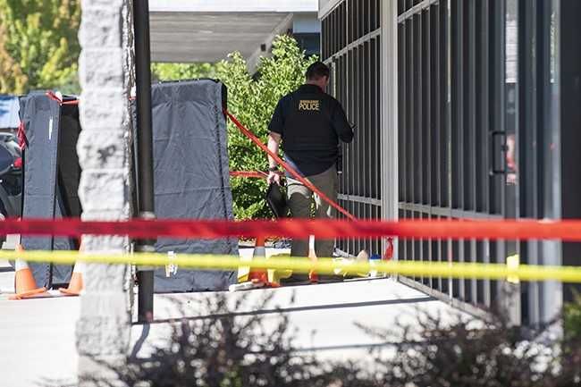 Rusty Rae/News-Register##An investigator works at the scene of the officer-involved shooting in McMinnville Tuesday afternoon.