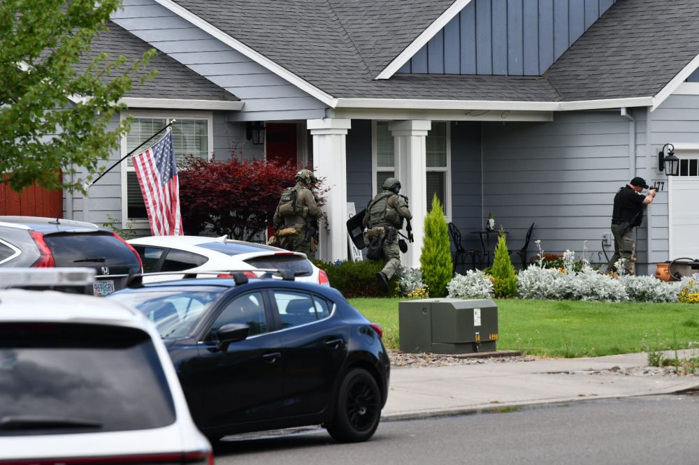 Rusty Rae/News-Register##Members of the police team responding to shots fired move in to surround the house on Mt. Mazama Street.