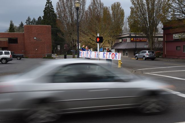 Rusty Rae/News-Register##
Two of the demonstrators with the largest sign wave to drivers passing   through the Third and Baker street intersection. A number of motorists honked in support of releasing the report on Mueller s investigation into Russian involvement  in U.S. elections.